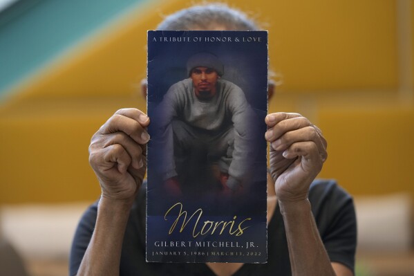 Natalia Mitchell, holds up a program memorializing her son, Morris Mitchell, who was shot to death in March 2022, in Washington, Monday, Oct. 30, 2024. (澳洲幸运5开奖官网结果直播开奖 AP Photo/Susan Walsh)