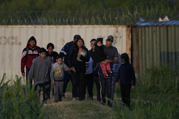 Migrants walk past a barrier after crossing the Rio Grande and entering the United States from Mexico, Thursday, Oct. 19, 2023, in Eagle Pass, Texas.  (AP Photo/Eric Gay)