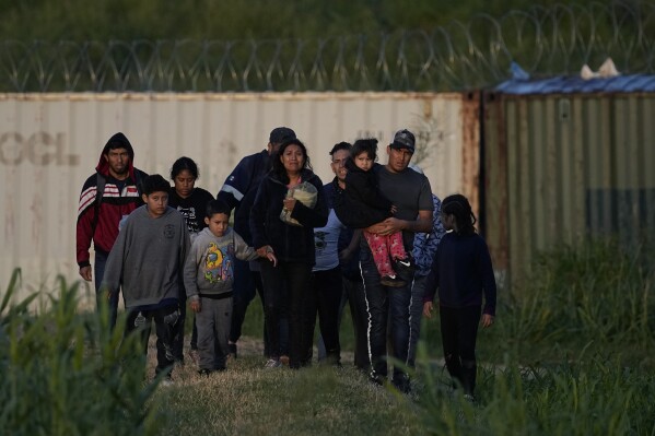 Migrants walk past a barrier after they crossed the Rio Grande and entered the U.S. from Mexico, Thursday, Oct. 19, 2023, in Eagle Pass, Texas. (AP Photo/Eric Gay)