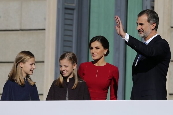 FILE - In this file photo dated Thursday, Dec. 6, 2018, Spain's King Felipe VI and his wife Queen Letizia wave to the crowd with their daughters Princess Leonor, left, and Princess Sofia during celebrations of the 40th anniversary of the Spanish Constitution at the Spanish parliament, in Madrid, Spain.  Heir to the Spanish throne, 15-year-old Princess Leonor will study a two-year course at UWC Atlantic College, in southern Wales, the Spanish royal household announced Wednesday Feb. 10, 2021. (AP Photo/Andrea Comas, FILE)