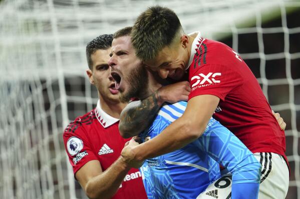 Manchester United's goalkeeper David de Gea, centre, celebrates with his teammates Manchester United's Lisandro Martinez, right, and Manchester United's Diogo Dalot during the English Premier League soccer match between Manchester United and West Ham United at Old Trafford stadium in Manchester, England, Sunday, Oct. 30, 2022. (AP Photo/Jon Super)