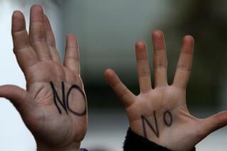 Protesters who wrote "NO" on their hands protesting outside of the parliament in capital Nicosia, Cyprus, Monday, March 18, 2013. A vote on a bailout package for Cyprus that includes an immediate tax on all savings accounts has been postponed until Tuesday evening. Yiannakis Omirou, the speaker of Parliament, said the delay was needed to give the government time to amend the deal reached over the weekend that prompted an outcry from those who thought their money was safe. In order to get euro10 billion ($13 billion) in bailout loans from international creditors, Cyprus agreed to take a percentage of all deposits — including ordinary citizens' savings — an unprecedented step in Europe's 3 ½-year debt crisis. (AP Photo/Petros Karadjias)