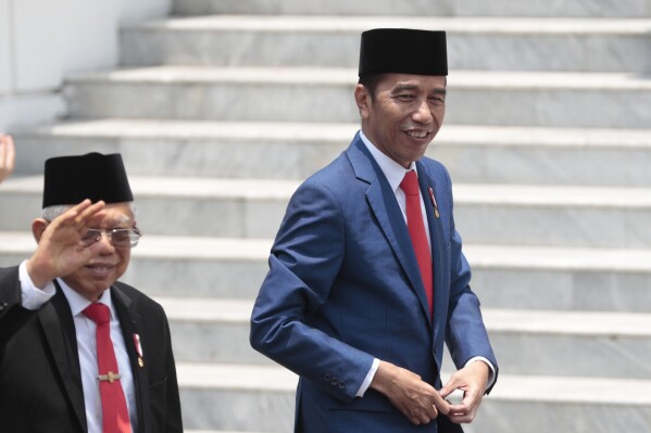 FILE - Indonesian President Joko Widodo, right, and his deputy Ma'ruf Amin arrive for a group photo with his new cabinet ministers after the swearing-in ceremony of the new cabinet at the Merdeka Palace in Jakarta, Indonesia, Wednesday, Oct. 23.  2019. Indonesia, the world's third-largest democracy, will cast about 205 million eligible voters to the polls in presidential and legislative elections on Wednesday, the fifth since Southeast Asia's largest economy began democratic reforms in 1998.  (AP Photo/Dita Alangkara, File)