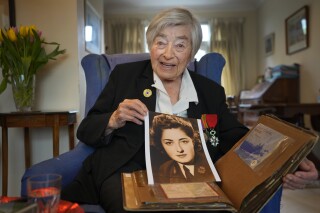 Patricia Owtram who was a serving Wren at the time of D-Day, shows a photograph of herself in wartime uniform, at her home in London, Wednesday, April 10, 2024. D-Day, took place on June 6, 1944, the invasion of the beaches at Normandy in France by Alied forces during World War II. (AP Photo/Kirsty Wigglesworth)