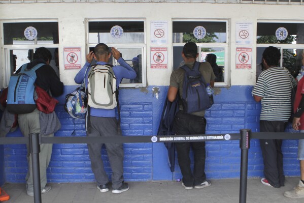 FILE - Migrants from El Salvador wait to be attended by Salvadoran migration authorities in La Hachadura, El Salvador, Wednesday, Oct. 31, 2018. Police in El Salvador on Tuesday, Nov. 14, 2023, arrested 10 people accused of operating a migrant smuggling ring that charged migrants up to $15,000 for the promise of safe travel to the U.S. (AP Photo/Diana Ulloa, File)