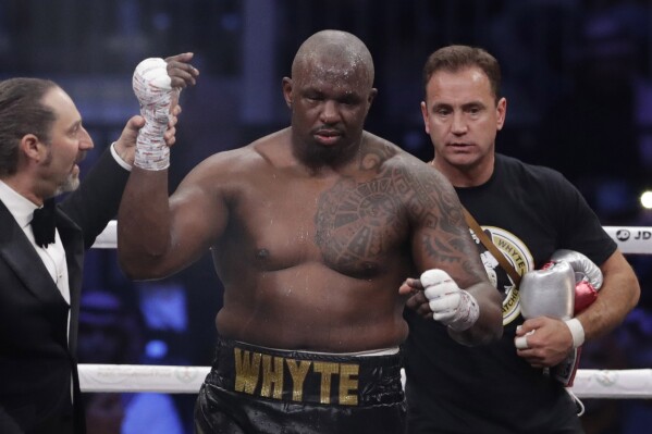 FILE - Dillian Whyte of Britain celebrates winning a heavyweight undercard boxing match against Mariusz Wach of Poland at the Diriyah Arena, in Riyadh, Saudi Arabia, Saturday, Dec. 7, 2019. Dillian Whyte's heavyweight rematch against Anthony Joshua was canceled after Whyte returned “adverse analytical findings” on a doping test, Matchroom Boxing said Saturday. The bout had been scheduled for Aug. 12 at London’s O2 Arena.(AP Photo/Hassan Ammar, File)