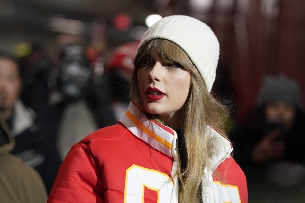FILE - Taylor Swift arrives before an NFL wild card playoff football game between the Kansas City Chiefs and the Miami Dolphins, Jan. 13, 2024, in Kansas City, Missouri.  For weeks, scrutiny over Swift's travels has been mounting on social media, with people pointing out the planet-warming carbon dioxide emissions released with each flight.  (AP Photo/Ed Zurga, File)