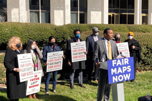 FILE - Reggie Weaver, at podium, speaks outside the Legislative Building in Raleigh, N.C., Feb. 15, 2022, about a partisan gerrymandering ruling by the North Carolina Supreme Court. The Supreme Court gave a win for the democratic principle of checks and balances in affirming that state courts can weigh in on legislative decisions affecting federal elections, but justices also left an opening for future challenges. (AP Photo/Gary D. Robertson, File)