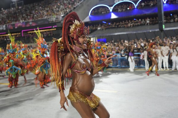 A pregnant woman from the Viradouro samba school parades during Carnival celebrations at the Sambadrome in Rio de Janeiro, Monday, March 3, 2025. (AP Photo/Silvia Izquierdo)