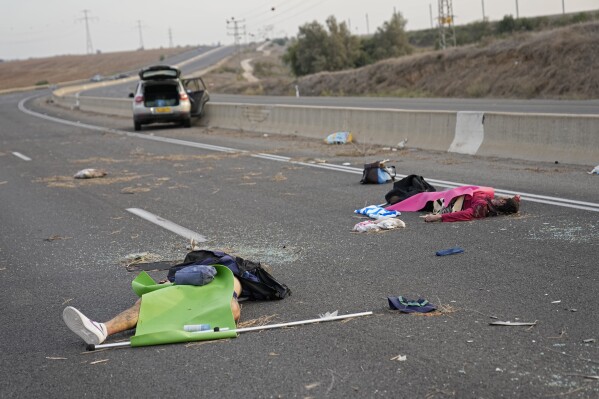 Israelis killed by Hamas militants lie on the road near Sderot, Israel, on Oct. 7, 2023. Palestinian militants from the Gaza Strip infiltrated southern Israel Saturday and fired thousands of rockets into the country, prompting Israel to begin striking targets in Gaza in response. (AP Photo/Ohad Zwigenberg)