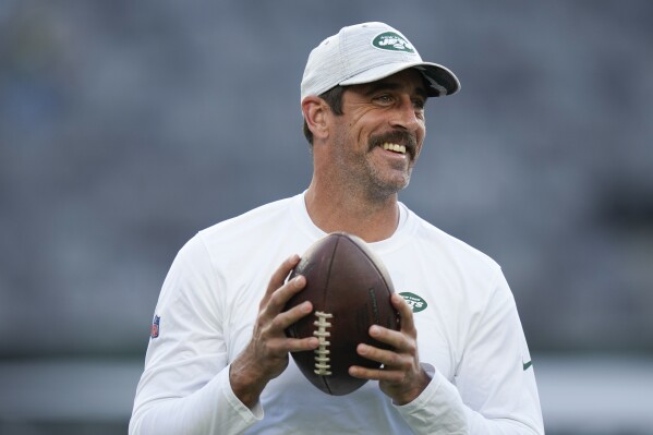 FILE - New York Jets quarterback Aaron Rodgers walks on the field during warm-ups before an NFL football game against the Tampa Bay Buccaneers, Saturday, Aug. 19, 2023, in East Rutherford, N.J. He’ll become a folk hero if he can lead the Jets to a Super Bowl for the first time since Broadway Joe Namath.(AP Photo/Seth Wenig, File)