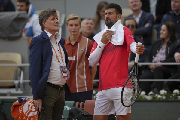 Serbia's Novak Djokovic talks with officials as he plays Mackenzie McDonald of the U.S. during their first round match of the French Tennis Open, at the Roland-Garros stadium, in Paris, Tuesday, May 27, 2025. (AP Photo/Thibault Camus)