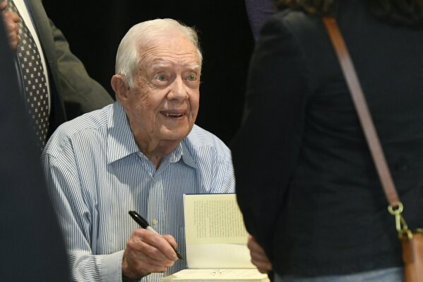 
              Former President Jimmy Carter signs copies of his new book "Faith: A Journey For All" Wednesday, April 11, 2018, in Atlanta. The book will debut at no. 7 on the New York Times best sellers list. (AP Photo/John Amis)
            