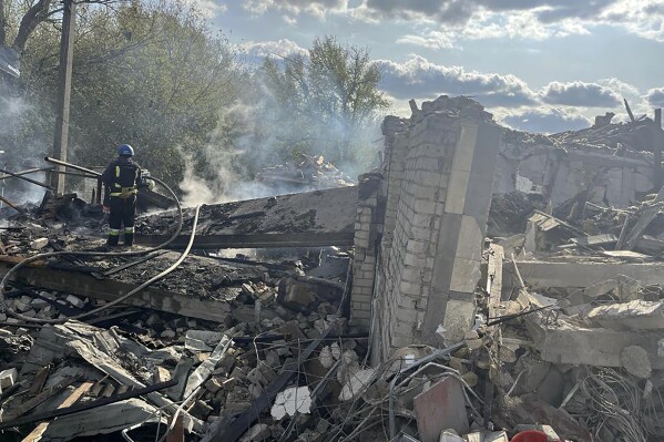 In this photo provided by the Ukrainian Presidential Press Office, firefighters work to extinguish a fire after the deadly Russian rocket attack that killed more than 40 people in the village of Hroza near Kharkiv, Ukraine, Thursday, Oct. 5, 2023. (Ukrainian Presidential Press Office via AP)