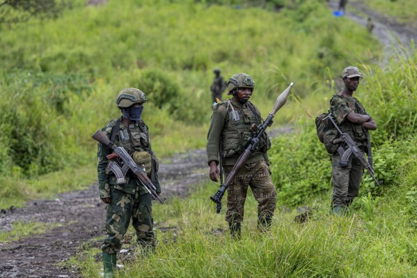 FILE - M23 rebels stand with their weapons in Kibumba, in the eastern of Democratic Republic of Congo, Dec. 23, 2022. M23, a rebel group with alleged links to Rwanda, has seized Rubaya, a mining town in eastern Congo known for producing a key mineral used in smartphones, the group said Thursday, May 2, 2024, in a statement. (AP Photo/Moses Sawasawa, File)
