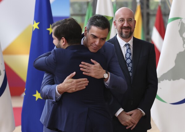 Spain’s Prime Minister Pedro Sanchez, center, and Chile's President Gabriel Boric hug prior a round table meeting at the third EU-CELAC summit that brings together leaders of the EU and the Community of Latin American and Caribbean States in Brussels, Belgium, Monday, July 17, 2023. (AP Photo/Francois Walschaerts)