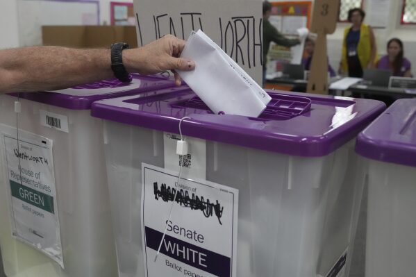 A ballot is dropped into a a box as early voting begins in Sydney, Tuesday, April 22, 2025, for a national election to be held on May 3. (AP Photo/Mark Baker)