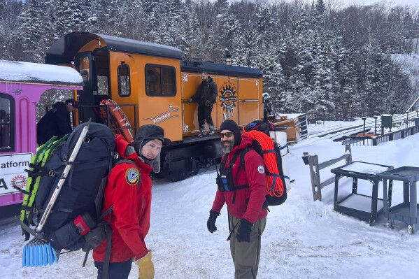 In this image provided by New Hampshire Fish and Game, New Hampshire Fish and Game conservation officer Levi Frye, left, and Jeremy Broughton, from Androscoggin Valley Search and Rescue, prepare to head out on a rescue mission at the Cog Railway base station, Saturday, Feb. 17, 2024, in Mount Washington, N.H. A team of rescuers used the Cog Railway to shave off time but it still took more than 10 hours to save a hiker in conditions that included sustained winds topping 90 mph (145 kph) on New Hampshire's Mount Washington, officials said. (Sgt. Glen Lucas/New Hampshire Fish and Game via AP)