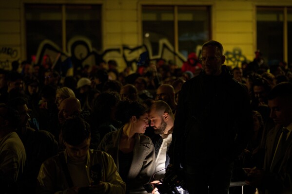 Supporters of presidential candidate Nicusor Dan touch foreheads after polls closed for the second round of the country's presidential election redo in Bucharest, Romania, May 18, 2025. (AP Photo/Andreea Alexandru)