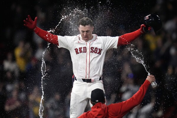 Boston Red Sox's Romy Gonzalez is doused with water after his game-winning RBI single in the 12th inning of a baseball game against the Tampa Bay Rays at Fenway Park, Tuesday, May 14, 2024, in Boston. The Red Sox won 5-4. (AP Photo/Charles Krupa)