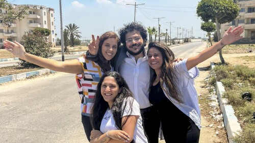 This photo provided by Marise George, shows her brother, Patrick George Zaki, top center, a prominent Egyptian rights activist with ties to Italy, celebrating with his family, Thursday, July 20, 2023, outside the Dakahlia security headquarters in the Nile Delta city of Mansoura, 110 kilometers (70 miles) north of Cairo, Egypt, after he was pardoned by Egyptian President Abdel Fattah el-Sissi along with five other people, according to the country's Official Gazette. Patrick was released from jail Thursday, days after he was sentenced to three years' imprisonment, according to his family and a rights defender. (Marise George via AP)