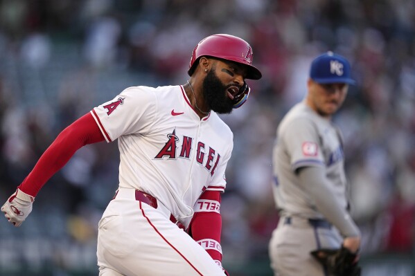 Los Angeles Angels' Jo Adell, left, celebrates as he rounds first after hitting a three-run home run while Kansas City Royals first baseman Vinnie Pasquantino watches during the second inning of a baseball game Saturday, May 11, 2024, in Anaheim, Calif. (AP Photo/Mark J. Terrill)