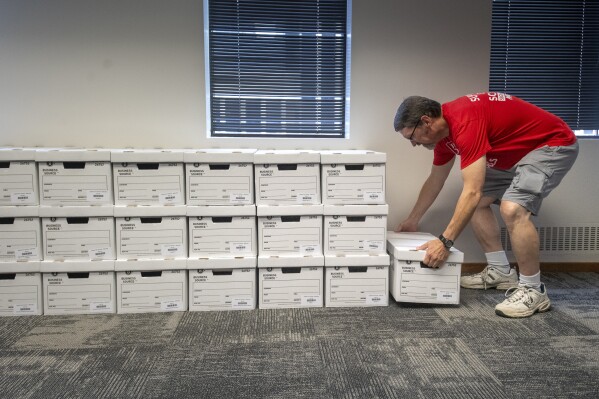 FILE - John Heineman delivers a box of petition signatures from Support Our Schools Nebraska to the Nebraska Secretary of State, Aug. 30, 2023, in Lincoln, Neb. Nebraska Secretary of State Bob Evnen announced Thursday, May 16, 2024, that a measure to repeal a now-defunct law passed last year that would use public money to fund private school tuition has been pulled from Nebraska’s November ballot. (Justin Wan/Lincoln Journal Star via AP, File)