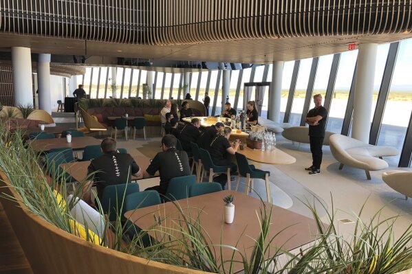 Virgin Galactic employees gather in the ground floor lounge at Spaceport America near Upham, New Mexico, on Thursday, Aug. 15, 2019. Virgin Galactic unveiled some of the interior spaces of the custom-tailored terminal Thursday, saying the designs are aimed at connecting the customers with operations as they prepare for their suborbital flights. (AP Photos/Susan Montoya Bryan)