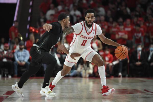 Houston guard Kyler Edwards (11) is defended by Central Florida guard Darius Johnson during the second half of an NCAA college basketball game Thursday, Feb. 17, 2022, in Houston. (AP Photo/Justin Rex)