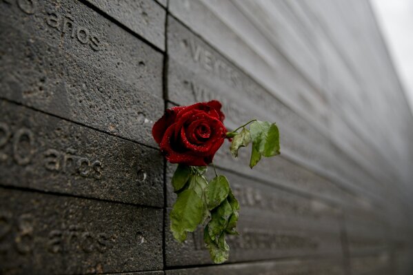 FILE - This May 7, 2017 file photo shows a rose on a wall with names of people who disappeared during Argentina's last dictatorship, to Memory Park to honor the victims of the country's dictatorshi...