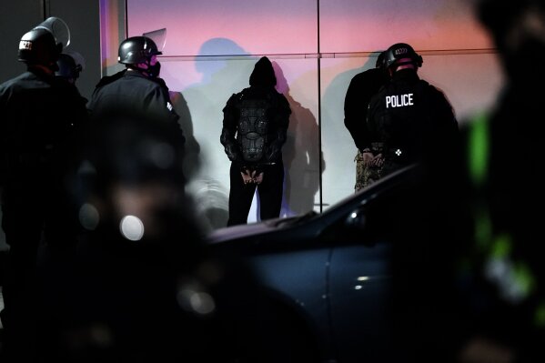 A man is detained by police on Election Day, Tuesday, Nov. 3, 2020, in Los Angeles. (AP Photo/Jae C. Hong)