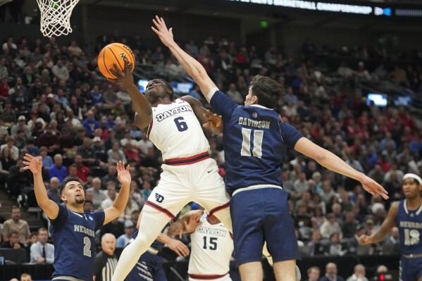 Dayton guard Enoch Cheeks (6) goes to the basket as Nevada forward Nick Davidson (11) defends during the first half of a first-round college basketball game in the NCAA Tournament in Salt Lake City, Thursday, March 21, 2024. (AP Photo/Rick Bowmer)