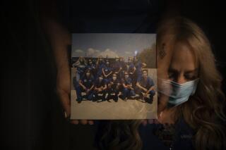 In this photo created with an in-camera multiple exposure, registered nurse Debbie Wooters, part of a group of nurses who had been treating coronavirus patients in an intensive care unit, holds a group picture taken with her fellow nurses in the empty COVID-19 ICU at Providence Mission Hospital in Mission Viejo, Calif., Tuesday, April 6, 2021. Many patients were frightened when told they would be put on a ventilator. Wooters remembers a patient who "looked at me and said, through his gasping breath, 'I don't want to die.'" (AP Photo/Jae C. Hong)