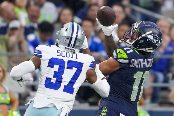 Seattle Seahawks wide receiver Jaxon Smith-Njigba catches a pass in front of Dallas Cowboys cornerback Eric Scott Jr. during the first half of a preseason NFL football game Saturday, Aug. 19, 2023, in Seattle. (AP Photo/Lindsey Wasson)