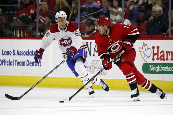 Carolina Hurricanes' Tony DeAngelo (77) looks to pass the puck around Montreal Canadiens' David Savard (58) during the first period of an NHL hockey game in Raleigh, N.C., Thursday, March 31, 2022. (AP Photo/Karl B DeBlaker)