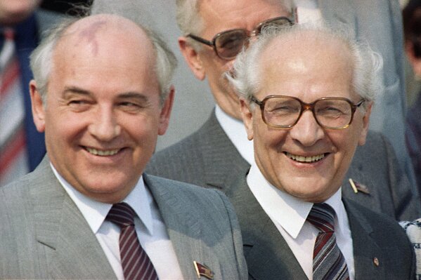 FILE - In this Wednesday, May 27, 1987 file photo, East Germany's head of state Erich Honecker, right, smiles as he welcomes Soviet leader Mikhail Gorbachev upon his arrival at East Berlin's Schoenefeld airport. Gorbachev encouraged Honecker and other Communist leaders in Central and Eastern Europe to follow his lead in launching liberal reforms and took no action to shore up their regimes when they started to crumble under the pressure of pro-democracy forces. (AP Photo/Heribert Proepper, File)