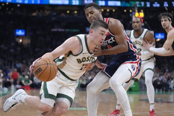 Boston Celtics guard Payton Pritchard, left, drives against Washington Wizards guard Jared Butler, front right, in the first half of an NBA basketball game, Sunday, April 14, 2024, in Boston. (AP Photo/Steven Senne)