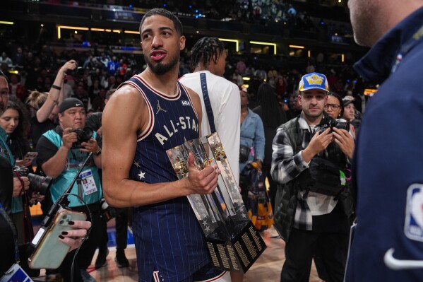 Indiana Pacers guard Tyrese Haliburton (0) carries the Championship trophy after the East defeated the West 211-186 in the NBA All-Star basketball game in Indianapolis, Sunday, Feb. 18, 2024. (APPhoto/Darron Cummings)