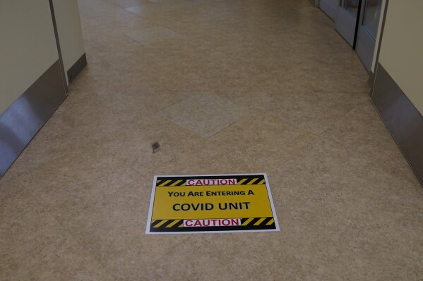 A caution sign is placed on the floor of a COVID-19 unit at St. Joseph Hospital in Orange, Calif., Thursday, Jan. 7, 2021. (AP Photo/Jae C. Hong)