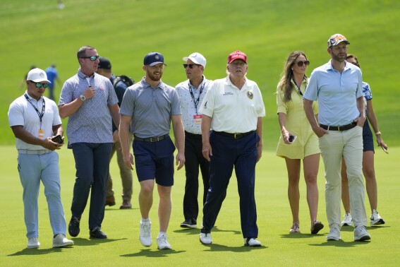 Former President Donald Trump, third from right, walks the course with Eric Trump, right, and Walt Nauta, far left, during the first round of the Bedminster Invitational LIV Golf tournament in Bedminster, N.J., Friday, Aug. 11, 2023. (AP Photo/Mary Altaffer)