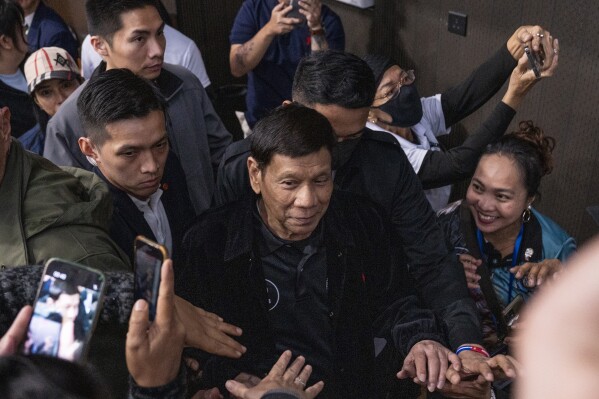 Former President of the Philippines Rodrigo Duterte arrives inside the Southorn Stadium during a thanksgiving gathering organized by Hong Kong-based Filipino workers for the former populist president in Hong Kong on Sunday, March 9, 2025. (AP Photo/Vernon Yuen)