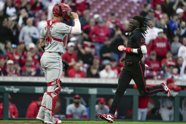 Cincinnati Reds' Elly De La Cruz, right, scores on a throwing error by Los Angeles Angels catcher Logan O'Hoppe in the second inning of a baseball game on Friday, April 19, 2024, in Cincinnati. (AP Photo/Carolyn Kaster)