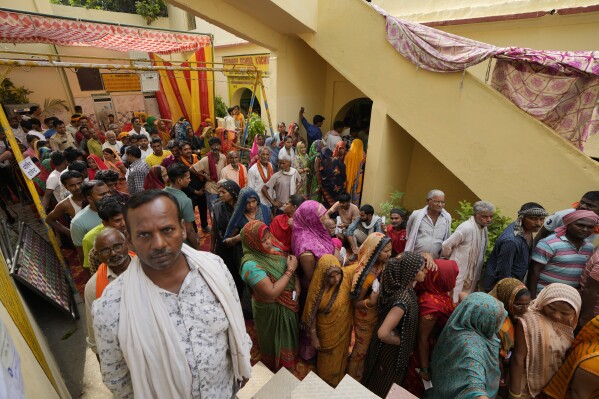 People stand in queues to cast their votes at a polling station during the last round of a six-week-long national election in Varanasi, India, Saturday, June 1, 2024. (AP Photo/Rajesh Kumar Singh)