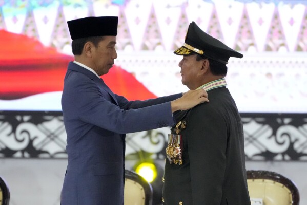 Indonesian Defense Minister Prabowo Subianto, right, receives four-star general epaulettes, from President Joko Widodo during a ceremony at the Armed Forces Headquarters in Jakarta, Indonesia, Wednesday, Feb. 28, 2024. President Joko Widodo on Wednesday awarded an honorary four-star general rank to Defense Minister Subianto, a former high-ranking army officer who is linked to human rights abuses and who emerged as the apparent winner of the Feb. 14 presidential election.(AP Photo/Achmad Ibrahim)