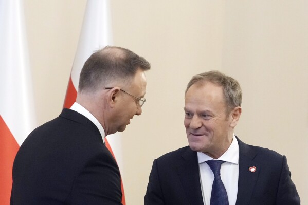 Poland's President Andrzej Duda, left, who is allied with the right-wing opposition, and new pro-European Union Prime Minister Donald Tusk shake hands before talks on Poland's security and continuing support for neighbouring Ukraine, at the Presidential Palace in Warsaw, Poland, Monday Jan. 15, 2024. Tusk is to travel to Kyiv in the coming days at the invitation of Ukraine President Volodymyr Zelenskyy. (AP Photo/Czarek Sokolowski)