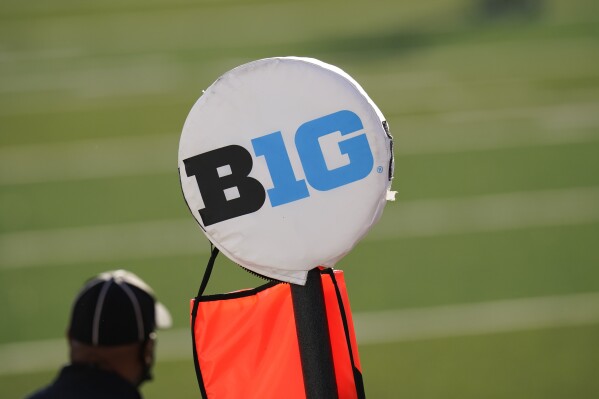 FILE - A Big Ten logo tops a yardage marker during the first half of an NCAA college football game between Iowa and Northwestern, Oct. 31, 2020, in Iowa City, Iowa. The Big Ten’s seven-year deal with Fox, CBS and NBC begins this week, marking the first time a college conference sold its rights to three broadcast networks.(AP Photo/Charlie Neibergall, File)