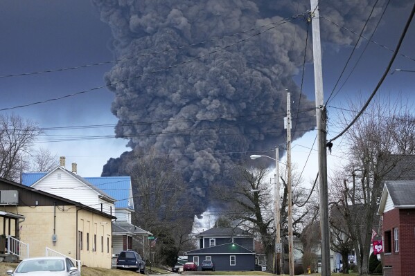 FILE - A black plume rises over East Palestine, Ohio, as a result of a controlled detonation of a portion of the derailed Norfolk Southern trains Monday, Feb. 6, 2023. Regulators say Norfolk Southern has made improvements since a fiery Ohio derailment but still falls well short of being the “gold standard for safety” it is striving to be. The Federal Railroad Administration released a report on the railroad’s safety culture Wednesday, Aug. 9. (AP Photo/Gene J. Puskar, File)