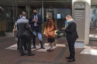 FILE - Former Theranos executive Ramesh "Sunny" Balwani, right, stands near his legal team outside Robert F. Peckham U.S. Courthouse in San Jose, Calif., on March 1, 2022. A jury on Tuesday, June 21 is scheduled to hear closing arguments in the trial of Balwani, the former Theranos officer charged with teaming up with his secret lover, CEO Elizabeth Holmes, to carry out a massive fraud. (AP Photo/Michael Liedtke, File)