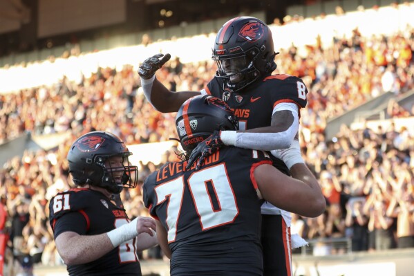 Oregon State wide receiver Rweha Munyagi Jr. (8) is lifted by offensive linemen Jake Levengood (70), next to Tanner Miller (61), as they celebrate Munyagi's touchdown against UC Davis during the first half of an NCAA college football game Saturday, Sept. 9, 2023, in Corvallis, Ore. (AP Photo/Amanda Loman)