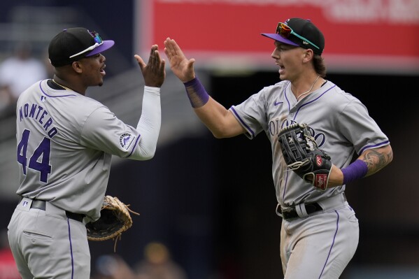 Colorado Rockies left fielder Jordan Beck, right, celebrates with teammate first baseman Elehuris Montero after the Rockies defeated the San Diego Padres 8-0 in a baseball game, Wednesday, May 15, 2024, in San Diego. (AP Photo/Gregory Bull)